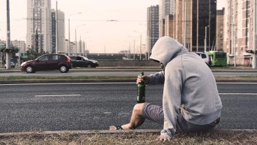 Leczenie uzależnień - przykład osoby uzależnionej od alkoholu leżącej na ulicy